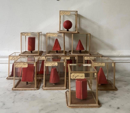 Set of Red Geometric Shapes in Individual Glass Cubes